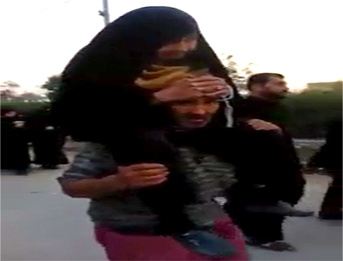 زائر ايراني يحمل امه على ظهره في مشاية الاربعين
